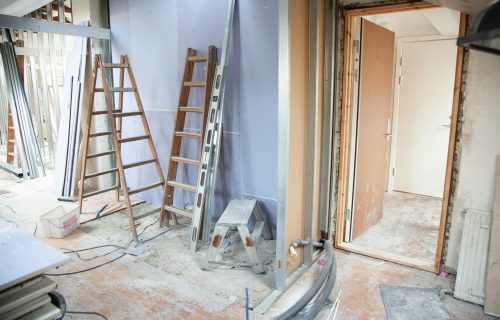 Construction site featuring ladders and tools in a home renovation setting.